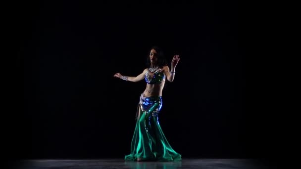 Κορίτσι που κάνει χορό της κοιλιάς σε σκοτεινό στούντιο. Μαύρο φόντο. Αργή κίνηση — Αρχείο Βίντεο