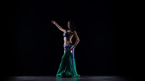 Meisje dansen in groene jurk op zwarte achtergrond. Slow Motion — Stockvideo