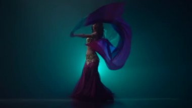 Karanlık stüdyoda kadın dans oryantal dans. Duman geçmişi. Yavaş hareket
