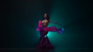 Gözleri karanlık stüdyoda oryantal dans dans elleri bir peçe ile kız. Duman geçmişi. Yavaş hareket