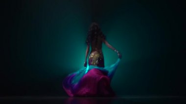 Karanlık stüdyoda kız dans oryantal dans. Duman geçmişi. Yavaş hareket