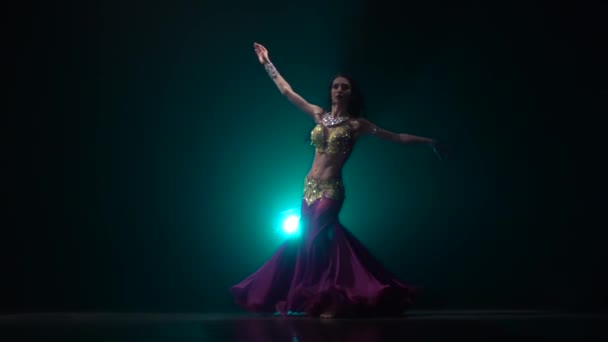 Bailarina del vientre que está empezando a sacudir sus caderas. Fondo de humo. Movimiento lento — Vídeo de stock