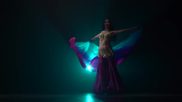 Une danseuse arabe danse le ventre sur scène. Fumée de fond. Mouvement lent — Video