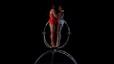 Acrobats spin ve sahnede çeşitli stunts gerçekleştirin. Siyah arka plan