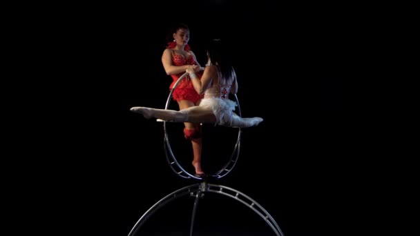 2人の女性が空中フープに要素を作ります。黒の背景 — ストック動画
