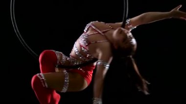 Bej Leotard içinde Dancer kadın dengeleyici arka siyah arka planda hava çember üzerinde asılı yatıyor. Yavaş hareket. Yakın çekim