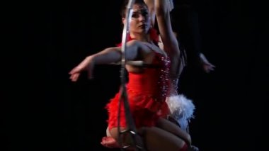 İki esnek jimnastikler hava çember metal inşaat üzerinde hüner. Siyah arka plan. Yavaş hareket. Yakın çekim