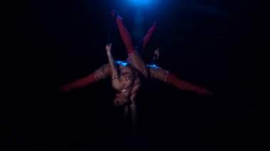 İki kız çember içinde dolaşıyor. Siyah arka plan. Yavaş hareket