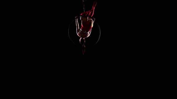 Girl performs the acrobatic in costume elements in the air ring. Black background. Slow motion — Stock Video