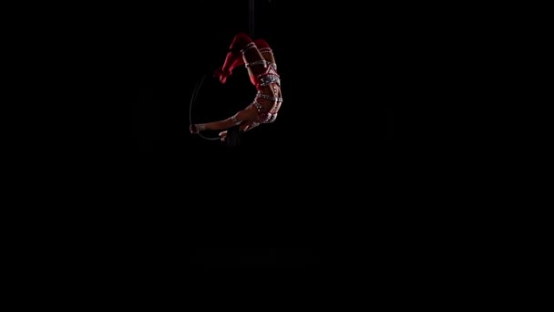 Mujer colgando en el ring por acrobacias aéreas. Fondo negro. Movimiento lento — Vídeo de stock