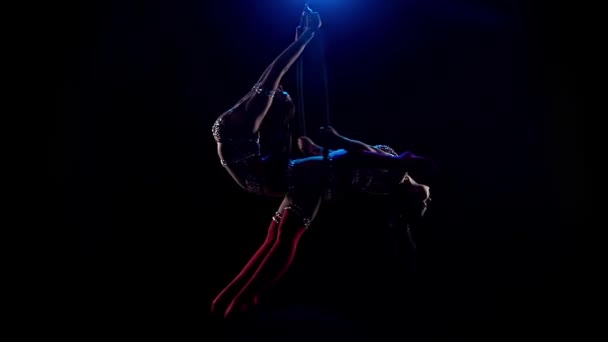 Acrobats realiza un truco gimnástico en el aro aéreo. Fondo negro. Movimiento lento — Vídeo de stock