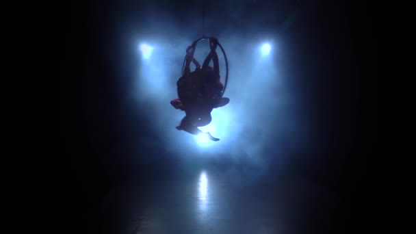 Air akrobaták lányok forgatni kecsesen a levegőben egy fém abroncs. Fekete füst háttér. Sziluett. Lassított mozgás — Stock videók