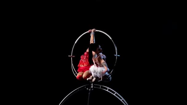 Två gymnaster utför ett trick på antennen Hoop metall konstruktion. Svart bakgrund. Slow motion — Stockvideo