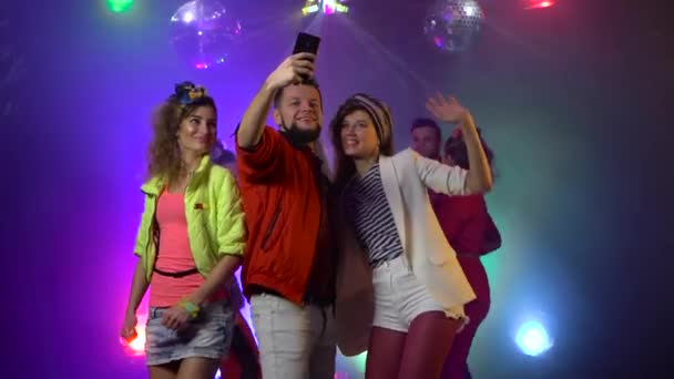 Улыбающиеся привлекательные тусовщики делают селфи в ночном клубе — стоковое видео