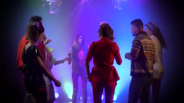 Club retro chica de la música canta alrededor de la gente bailando para cantar. Fondo de humo — Vídeo de stock