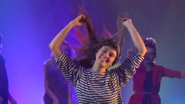 Fiatalok csoportja, akik felemelt fegyverekkel táncolnak a zenére — Stock videók