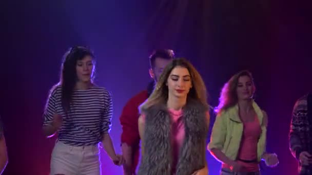 Grupo de pessoas dançando para música legal com luzes de discoteca. Fundo de fumo — Vídeo de Stock