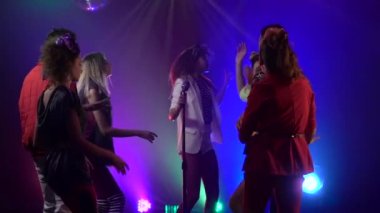 Kadın Retro bir mikrofon sahne üzerinde duman stüdyosunda izleyici dansları olarak performans şarkı. Duman geçmişi. Yavaş hareket