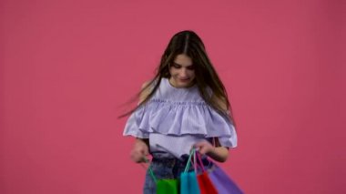 Kız çantadan bir ayakkabı alır ve mutlu. Pembe arka plan