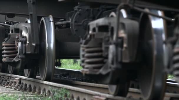 Räder des sich entlang der Schienen bewegenden Zuges in Nahaufnahme. Zeitlupe — Stockvideo