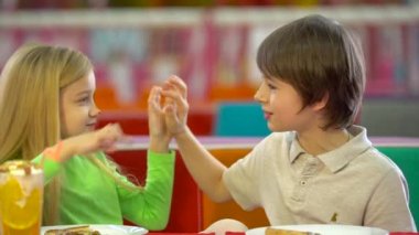 Eğlence merkezinde akşam yemeğinde çikolata pizza yiyen mutlu çocuklar.