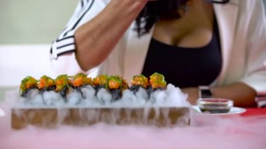 Sushi alan Chopsticks ile WOMANS el kafede duman hizmet.