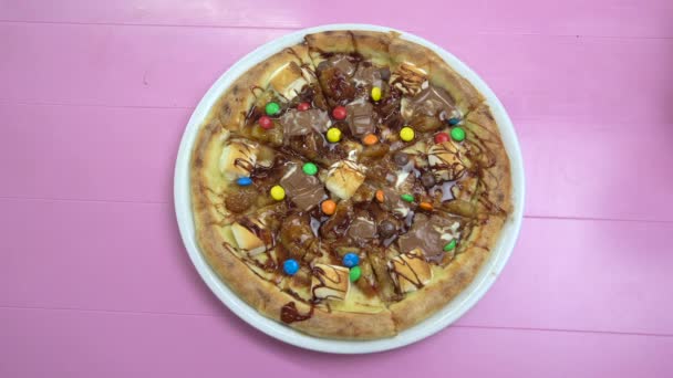 Pizza mit geschmolzener Schokolade und bunten Bonbons. — Stockvideo