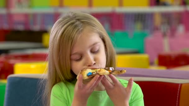 Klein meisje dat chocolade pizza eet tijdens het diner bij Childrens café. — Stockvideo