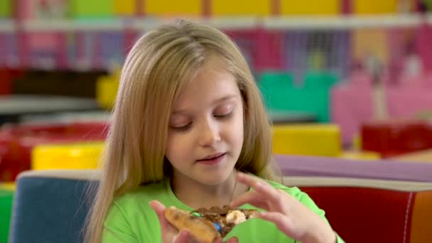 Pretty child enjoying chocolate pizza during supper at childrens restaurant. — Stock Video