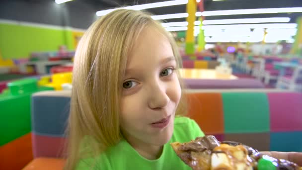 Közeli mozgás a lány étkezési pizza a szórakoztató központ. — Stock videók