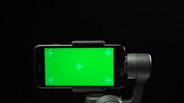 Mano levantándose estabilizador steadicam con pantalla verde en el smartphone . — Vídeos de Stock