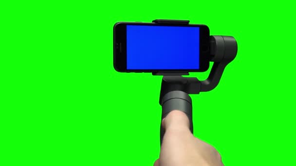 Ręka kontrolująca stabilizator Steadicam z niebieskim ekranem na smartfonie. — Wideo stockowe