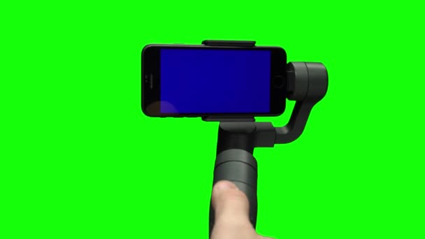 Tir à la main à l'aide du stabilisateur de cardan steadicam avec smartphone à écran bleu . — Video