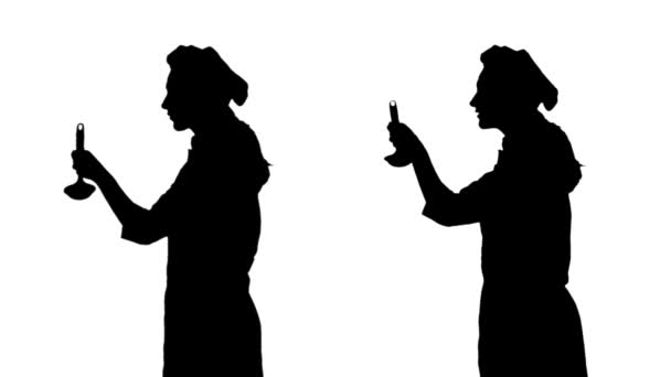 Zwei schwarze Silhouetten von Kochmädchen versuchen Gericht von Schöpfkelle. — Stockvideo