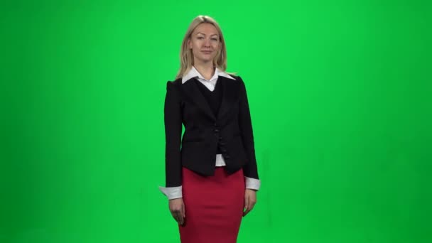 Vacker kvinna som visar något stående mot grön skärm Chroma nyckel bakgrund. — Stockvideo