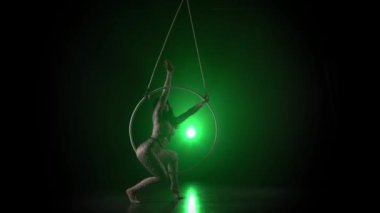 Ringde hava akrobat. Genç bir kız yeşil arka plan 014 üzerinde hava halkaakrobatik elemanları gerçekleştirir