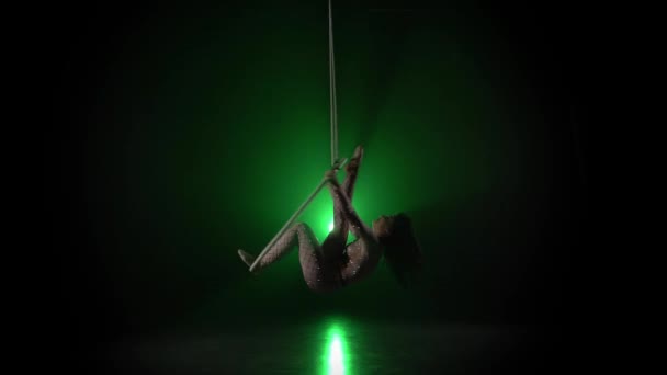 Lucht acrobaat in de ring. Een jong meisje voert de acrobatische elementen in de lucht ring op groene achtergrond 018 — Stockvideo