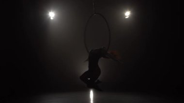 Silhouette Genç beyaz esmer sportif dansçı kadın dengeleyici bej Leotard arka ışık arka arkaya üç ışınları üzerinde hava çember askıda yatıyor 033