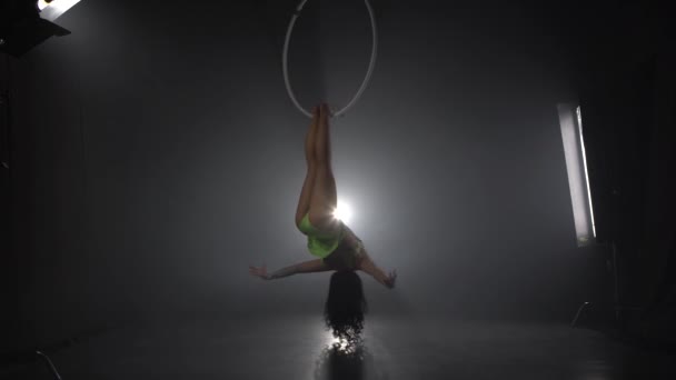 Aerial acrobat in the ring. A young girl performs the acrobatic elements in the air ring 041 — Stok video