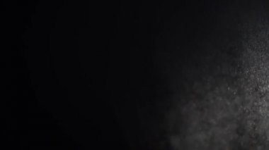 Yükselen doğal toz siyah bir stüdyo arka plan üzerinde parlıyor.