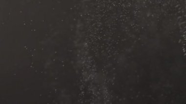 Yukarıdan aşağıya düşen mikroskobik toz parçaları. Yavaş çekim