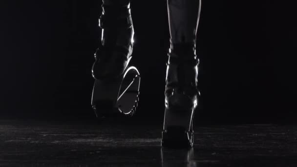 Närbild rörelse benen gör övningar i Kangoo hoppar skor. — Stockvideo