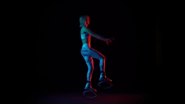 Girl in sports suit is dancing in kangoo jumps shoes. — Stock Video