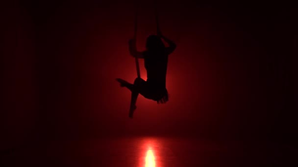 Silhouette aerialist Girl gör akrobatiska och flexibla tricks på röd antenn Silks vävnader på röd bakgrund 053 — Stockvideo