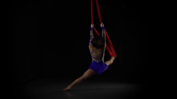 Gymnaste aérien féminin se produisant sur une soie rouge dans un fond noir. Spectacle acrobatique passionnant 060 — Video