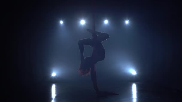 Elegantní gymnastka provádějící vzdušné cvičení s červeným hedvábím na modrém světle pozadí 086 — Stock video