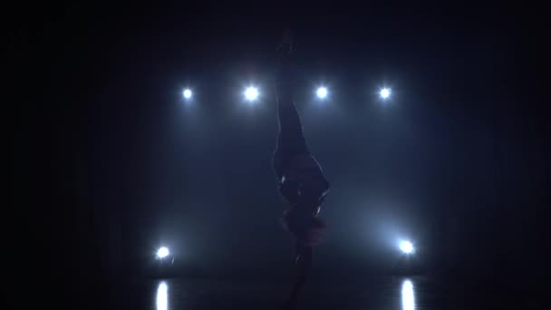 Graceful gymnast performing aerial exercise with red silk on blue light background 087 — Stock Video