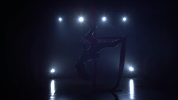 Elegantní gymnastka provádějící vzdušné cvičení s červeným hedvábím na modrém světle pozadí 088 — Stock video
