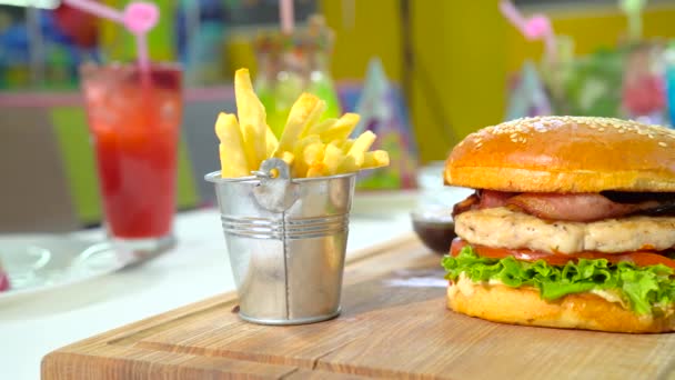 Festlig lunch med hamburgare, pommes frites och några färgade cocktails. — Stockvideo