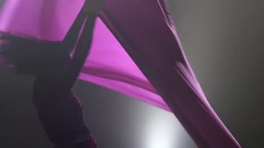 Woman aerial gymnast performing on violet silk in circus stage. Exciting acrobatic show. Slow motion. Closeup. 309